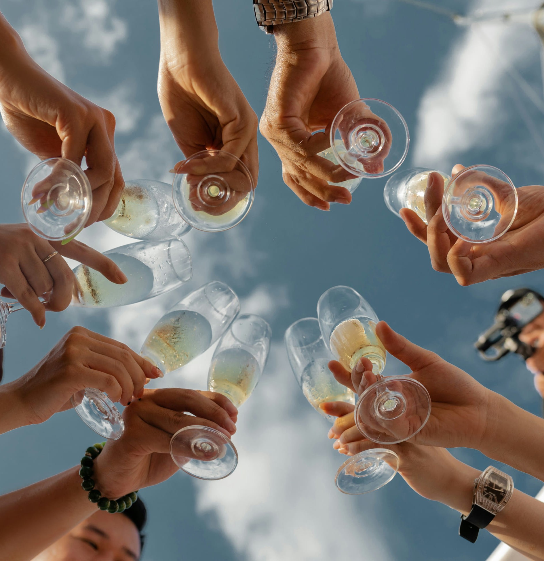 Mehrere Partygäste stoßen an mit Sekt bei einer Feier im Krallerhof. (c) Unsplash Quan Nguyen